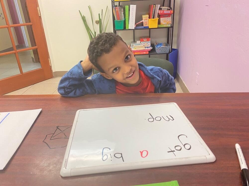 Preschooler writing letters at table