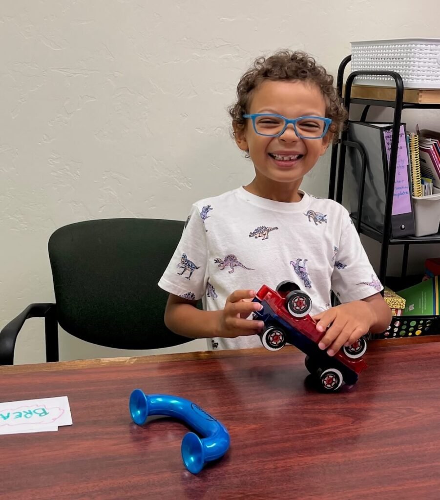 Preschooler holding toy and smiling