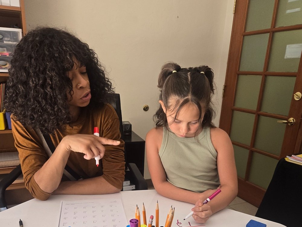 Math tutor and student writing equations