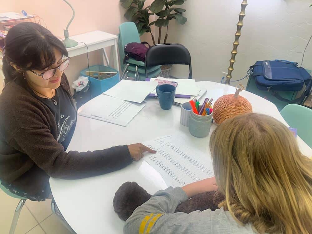 Dyslexia student with tutor pointing out words