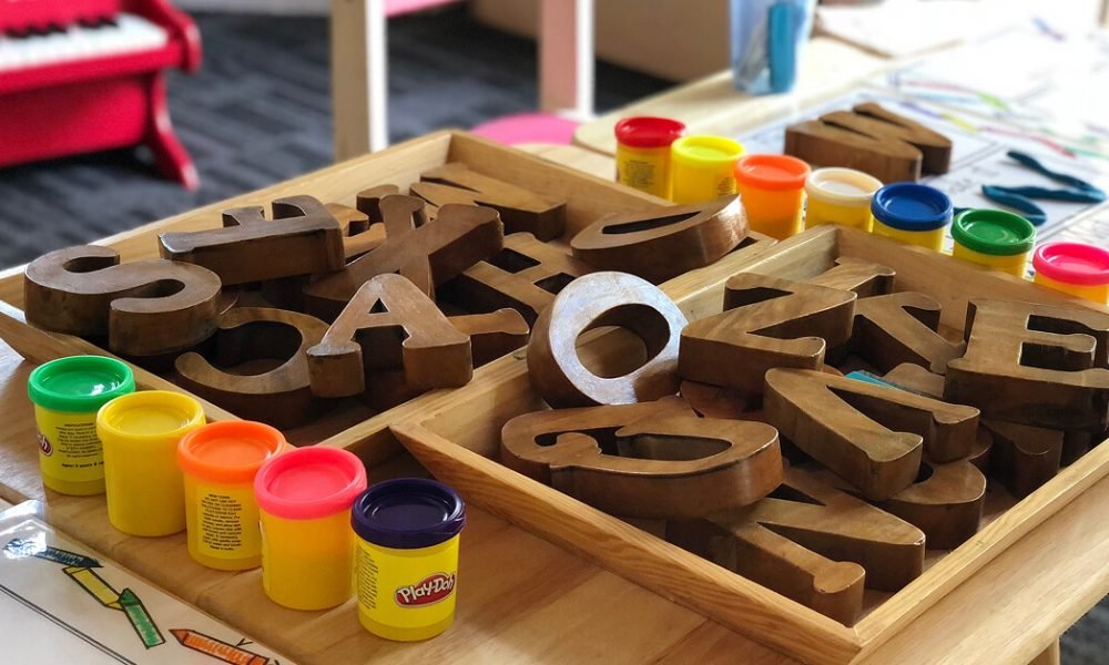 Preschool classroom with playdoh and wooden letters on table